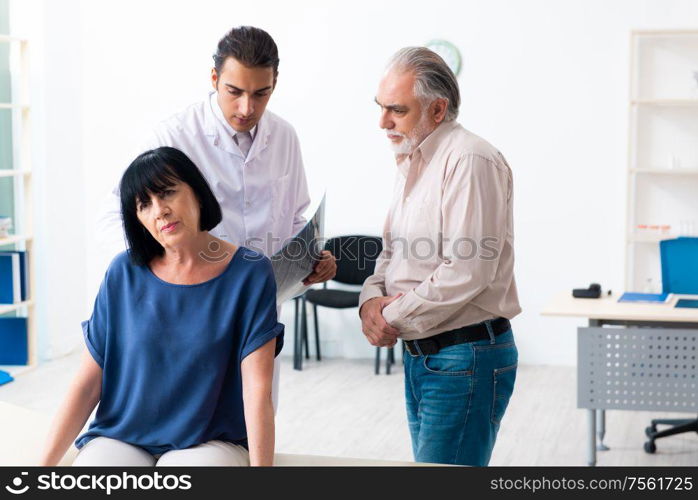 The old couple visiting young male doctor. Old couple visiting young male doctor