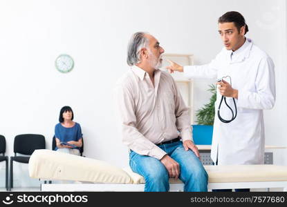 The old couple visiting young male doctor. Old couple visiting young male doctor