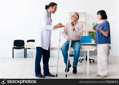 The old couple visiting young male doctor. Old couple visiting young male doctor