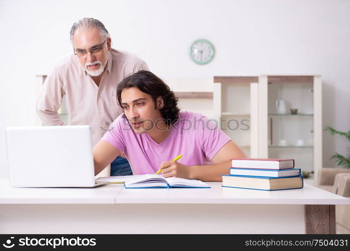 The old father helping his son in exam preparation. Old father helping his son in exam preparation