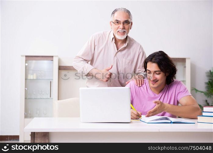 The old father helping his son in exam preparation. Old father helping his son in exam preparation