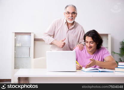 The old father helping his son in exam preparation. Old father helping his son in exam preparation