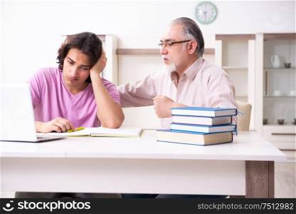 The old father helping his son in exam preparation. Old father helping his son in exam preparation