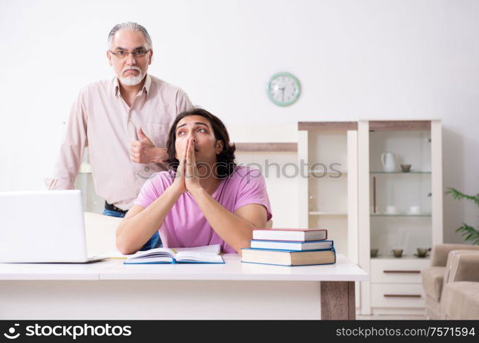 The old father helping his son in exam preparation. Old father helping his son in exam preparation