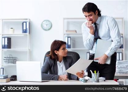 The old female boss and young male employee in the office  . Old female boss and young male employee in the office  