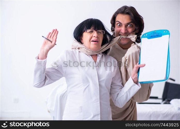 The old female psychiatrist visiting young male patient . Old female psychiatrist visiting young male patient 
