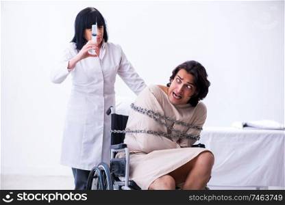 The old female psychiatrist visiting young male patient . Old female psychiatrist visiting young male patient 
