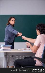 The old female teacher and male student in the classroom. Old female teacher and male student in the classroom