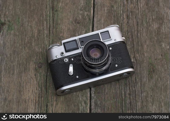 the old film camera lies on a wooden table