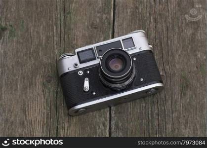 the old film camera lies on a wooden table