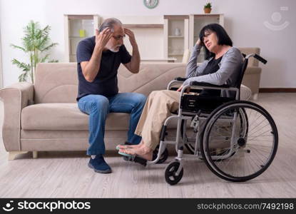 The old husband looking after disabled wife. Old husband looking after disabled wife