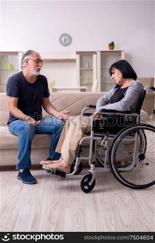 The old husband looking after disabled wife. Old husband looking after disabled wife