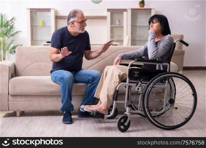 The old husband looking after disabled wife. Old husband looking after disabled wife