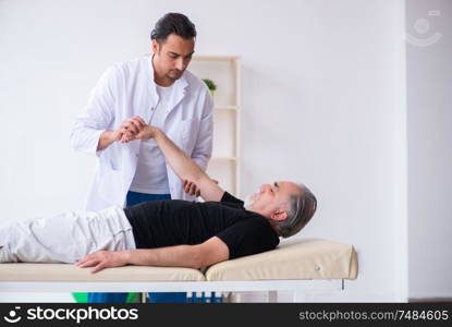 The old injured man visiting young doctor . Old injured man visiting young doctor