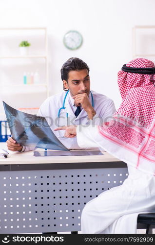 The old male arab visiting young male doctor. Old male arab visiting young male doctor