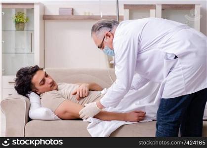 The old male doctor visiting young male patient  . Old male doctor visiting young male patient  