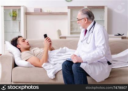The old male doctor visiting young male patient . Old male doctor visiting young male patient