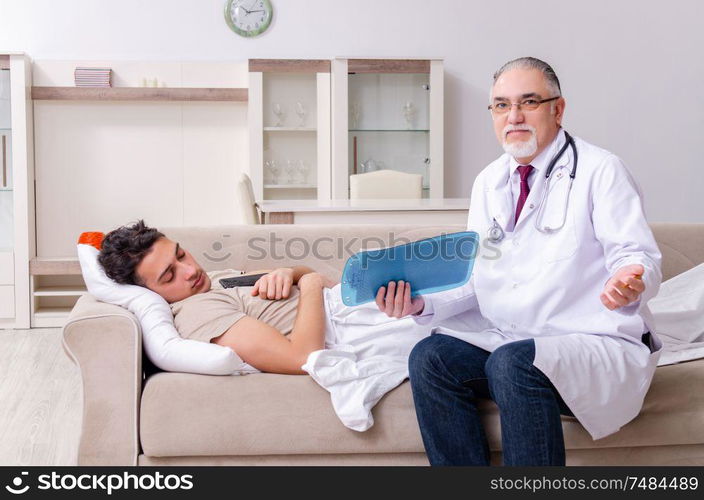 The old male doctor visiting young male patient. Old male doctor visiting young male patient