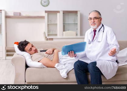 The old male doctor visiting young male patient. Old male doctor visiting young male patient