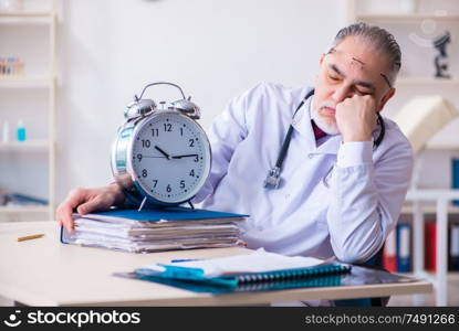 The old male doctor working in the clinic. Old male doctor working in the clinic