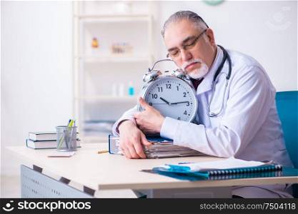 The old male doctor working in the clinic. Old male doctor working in the clinic