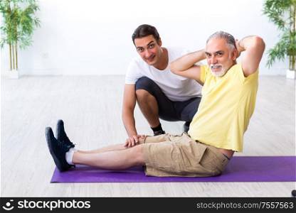 The old man doing exercises indoors. Old man doing exercises indoors