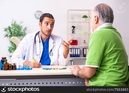 The old man visiting young male doctor gastroenterologist. Old man visiting young male doctor gastroenterologist