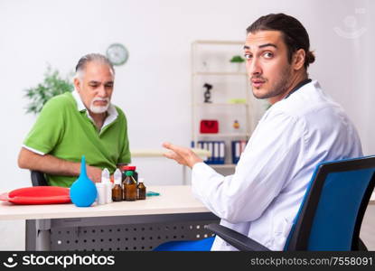 The old man visiting young male doctor gastroenterologist. Old man visiting young male doctor gastroenterologist