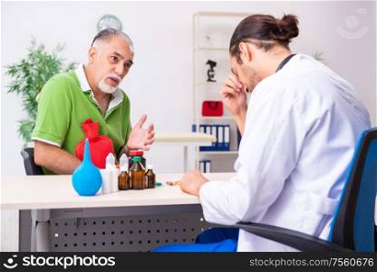 The old man visiting young male doctor gastroenterologist. Old man visiting young male doctor gastroenterologist