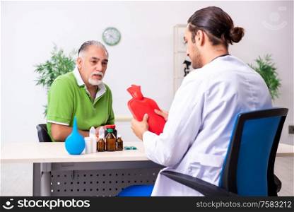 The old man visiting young male doctor gastroenterologist. Old man visiting young male doctor gastroenterologist