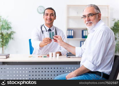 The old man visiting young male doctor. Old man visiting young male doctor