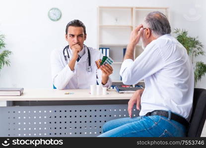 The old man visiting young male doctor. Old man visiting young male doctor