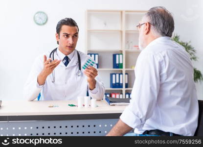 The old man visiting young male doctor. Old man visiting young male doctor