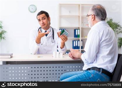 The old man visiting young male doctor. Old man visiting young male doctor