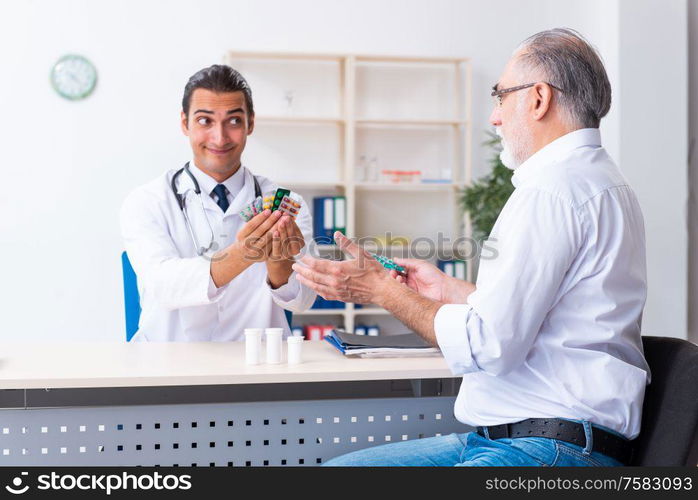 The old man visiting young male doctor. Old man visiting young male doctor