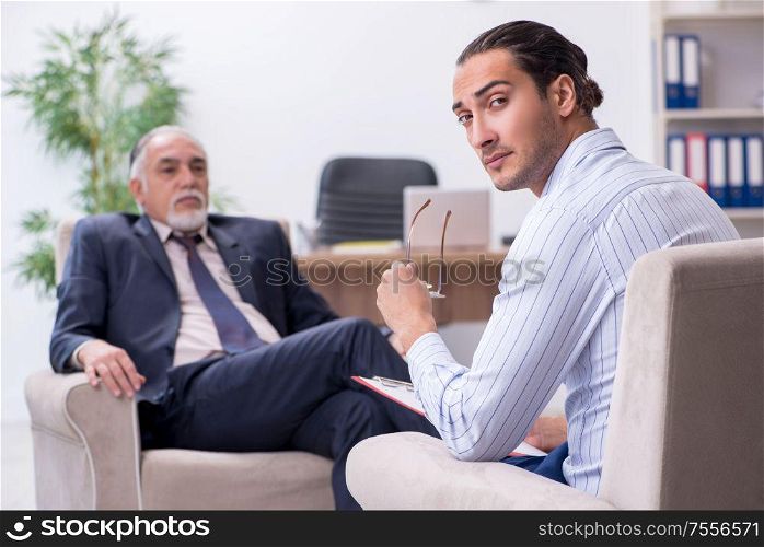 The old man visiting young male doctor psychologist. Old man visiting young male doctor psychologist