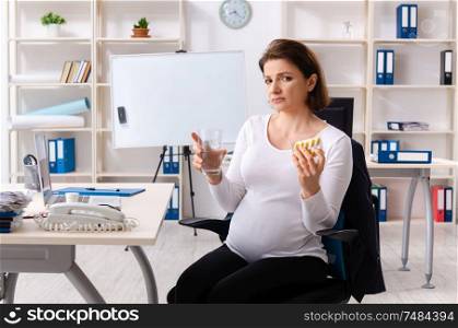 The old pregnant woman working in the office . Old pregnant woman working in the office