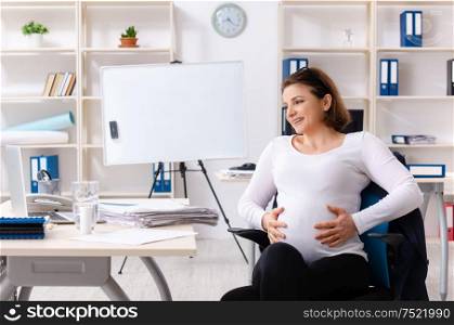 The old pregnant woman working in the office. Old pregnant woman working in the office