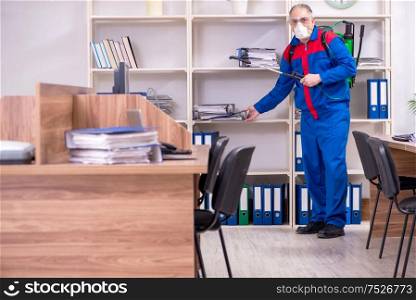 The old professional contractor doing pest control in the office. Old professional contractor doing pest control in the office