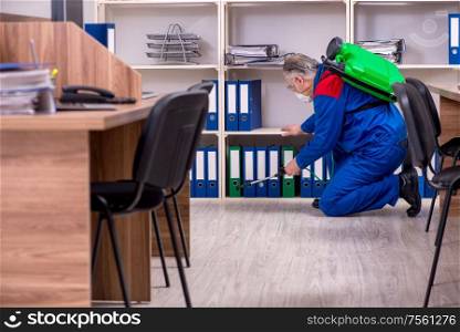 The old professional contractor doing pest control in the office. Old professional contractor doing pest control in the office