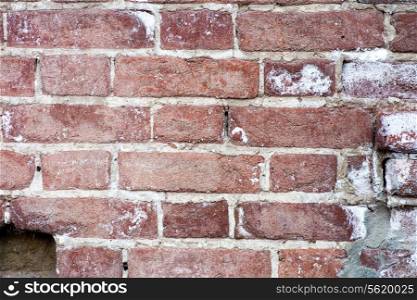 The old red brick wall. Red brick wall closeup background. It depicts an old brick wall crumbling