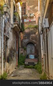 The old streets of acireale with a lonely car, catania, sicily.