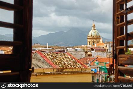 The old town of Palermo in Sicily through the open window with shutters, Italy