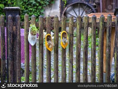 The old traditional shoes hang on the fence like decoration, noise