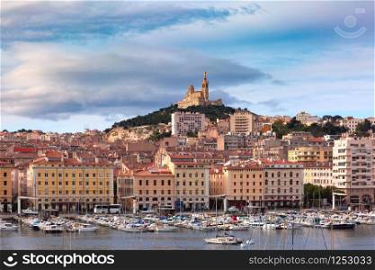 The old Vieux Port and Basilica Notre Dame de la Garde in the historical city center of Marseilles on sunny day, France. Old Port and Notre Dame, Marseille, France