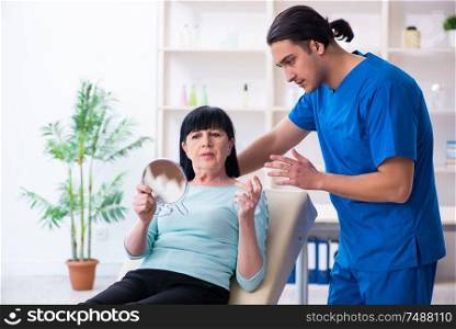The old woman visiting male doctor for plastic surgery . Old woman visiting male doctor for plastic surgery