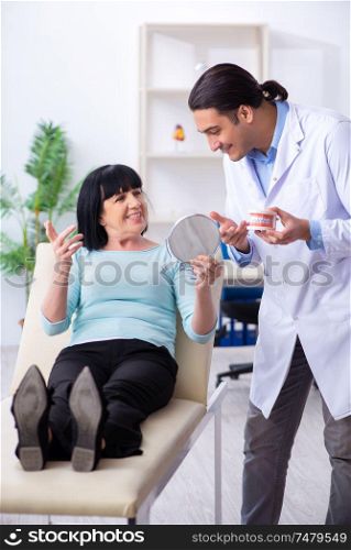 The old woman visiting young doctor dentist . Old woman visiting young doctor dentist