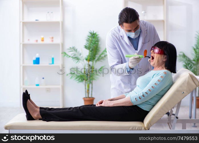 The old woman visiting young doctor dentist . Old woman visiting young doctor dentist