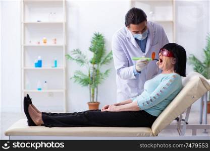 The old woman visiting young doctor dentist . Old woman visiting young doctor dentist