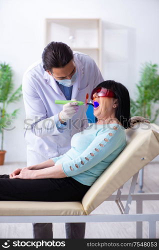 The old woman visiting young doctor dentist. Old woman visiting young doctor dentist